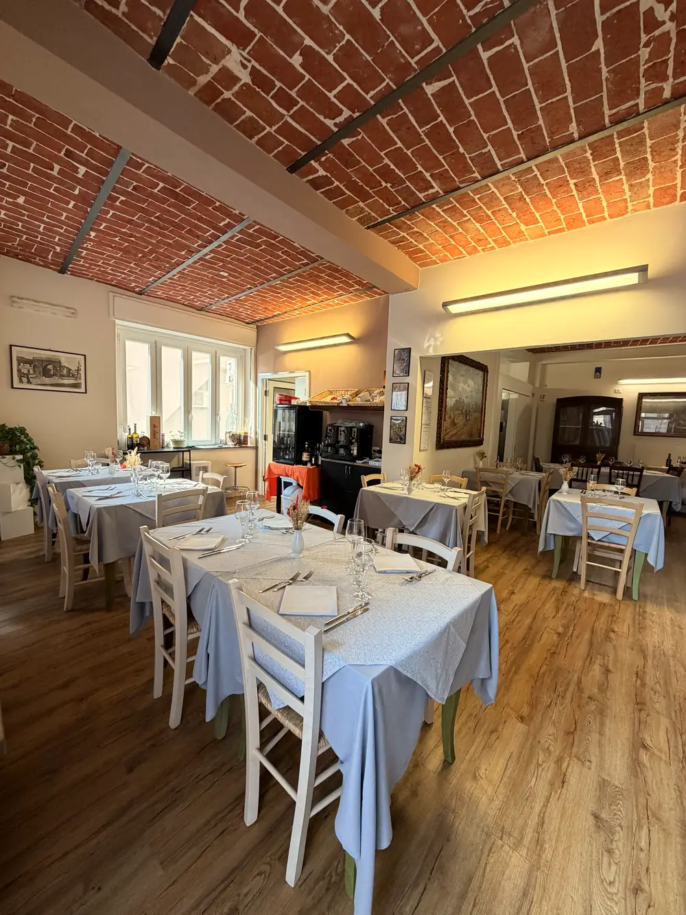 La sala con il soffitto a volta in mattoni e i tavoli apparecchiati.